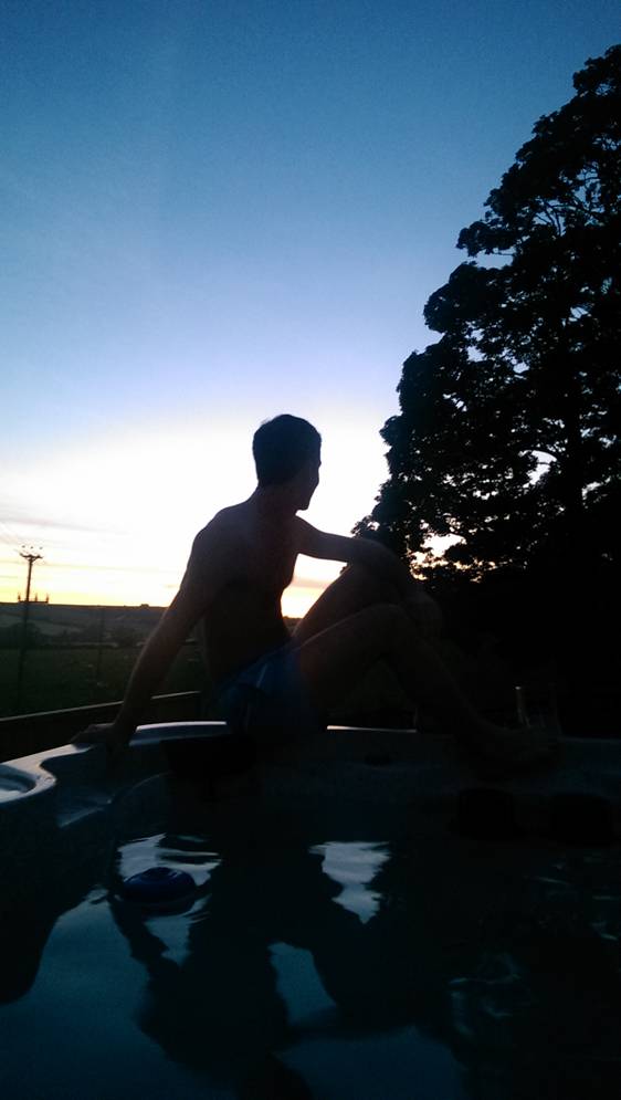 A man next to the hot tub overlook sunset
